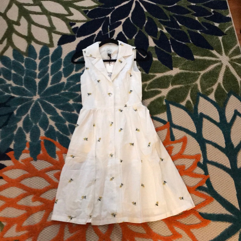 White dress with embroidered yellow flowers.